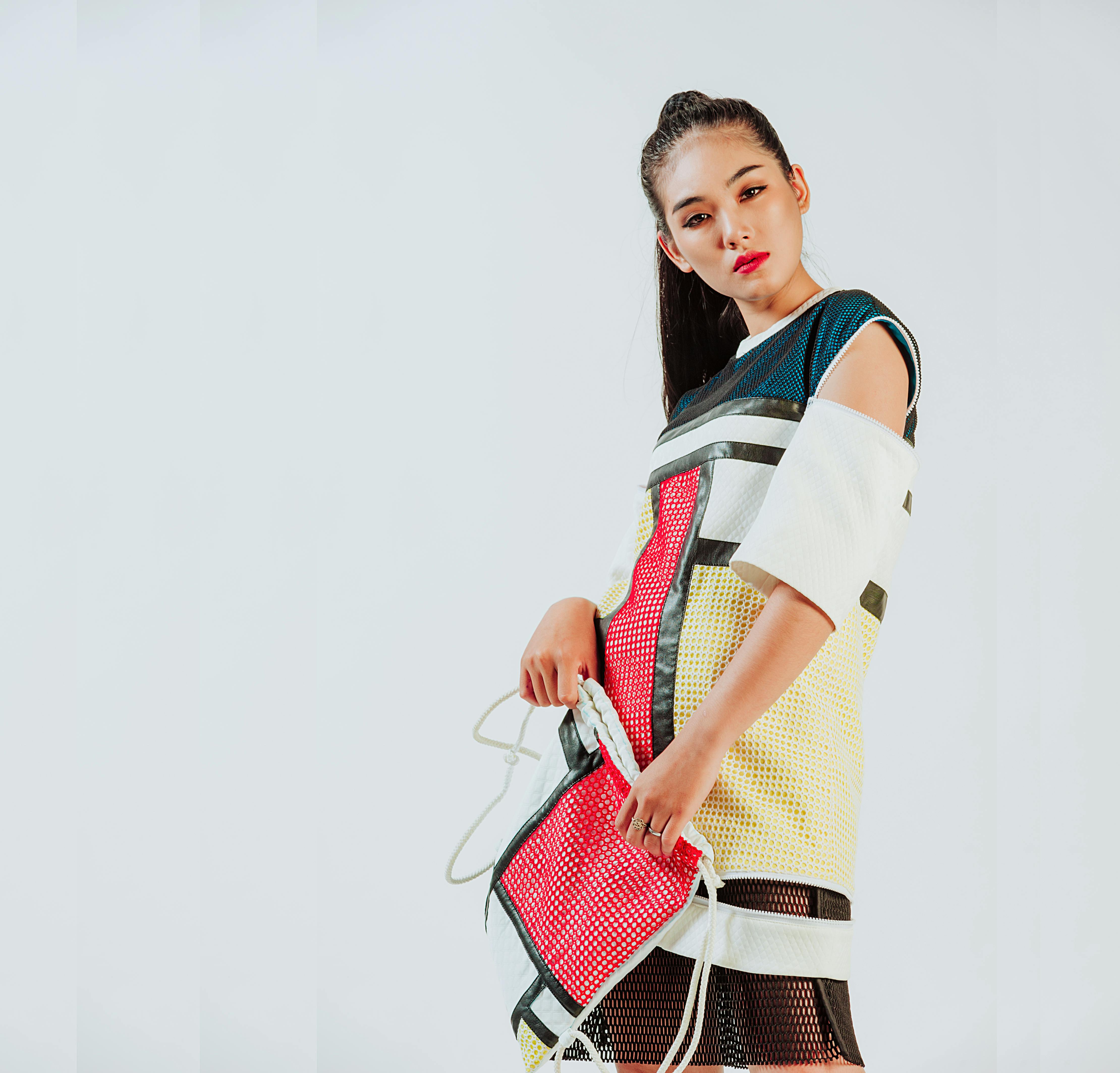 这幅肖像画中，一位年轻女子身着时尚缤纷的服装，展现出当代的优雅风范