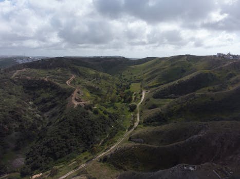 Dramatic aerial landscape of Mexican hills under a cloudy sky, showcasing natural beauty.
