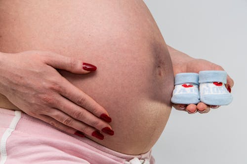 Pregnant Woman Holding Blue and White Socks