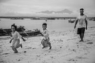 Children running on Shore with their Father behind them
