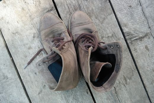 Broken-in boots on planking, photo by Alexey Demidov on Pexels