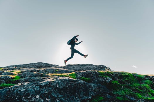 A person jumping over rocks with a clear sky background in British Columbia, Canada.