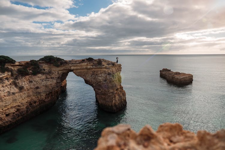 Woman Standing On The Edge Of Arco De Albandeira, Porches, Portugal 