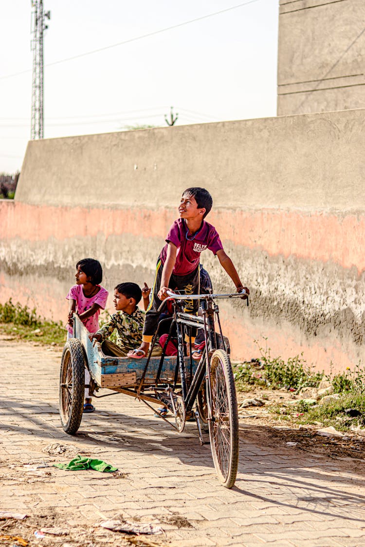 Children Riding A Bicycle With Carriage