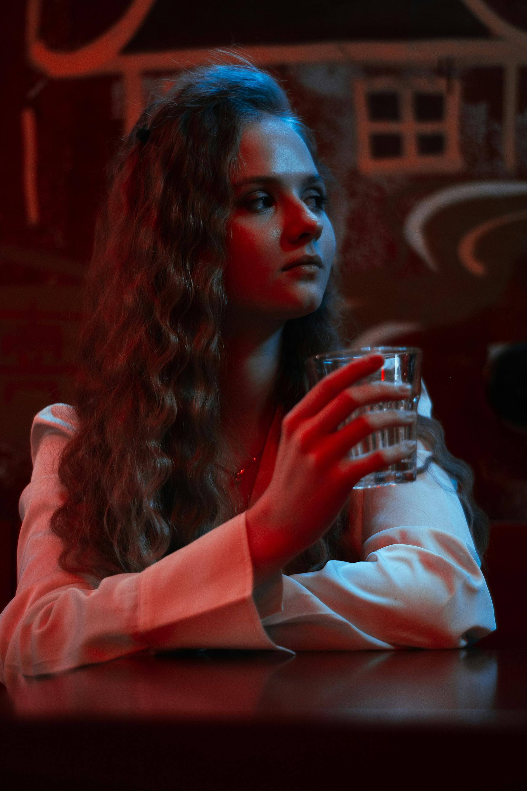 a woman with a wavy hair drinking at the bar