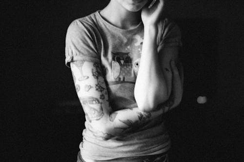 Grayscale Photo of Woman with Arm Tattoo