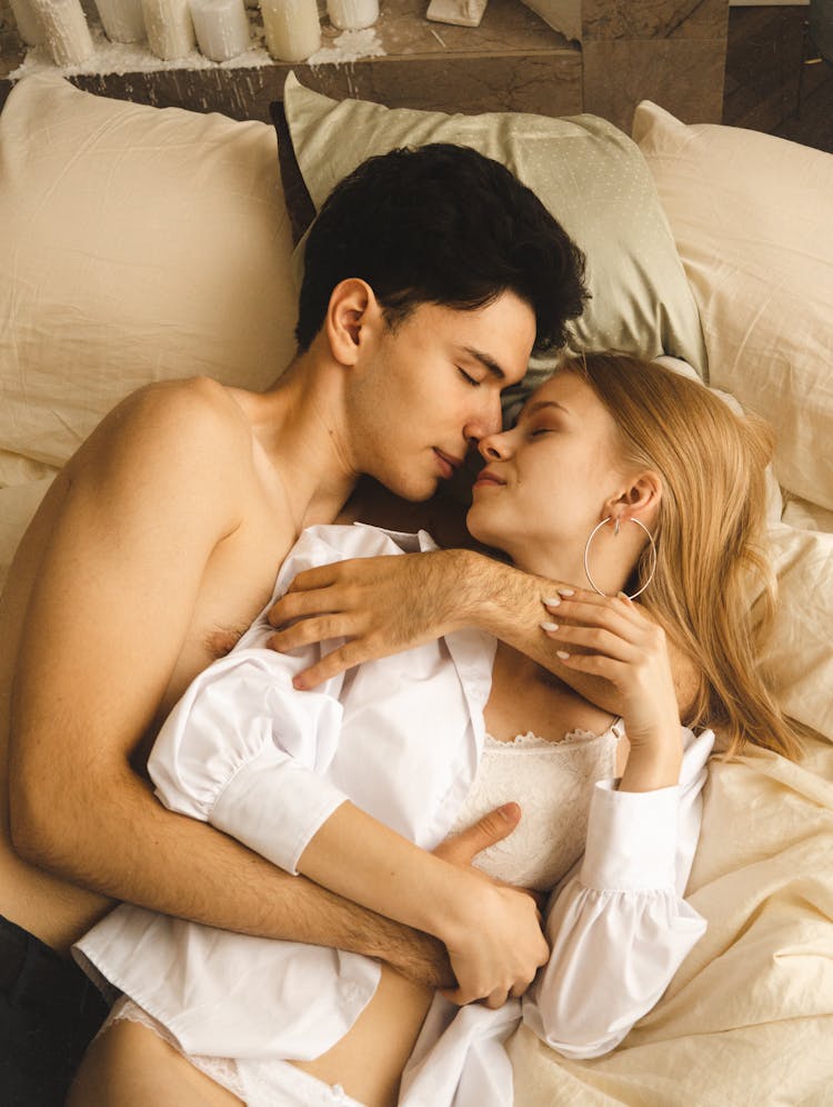 Brunette Man And Blonde Woman Hugging In Bed