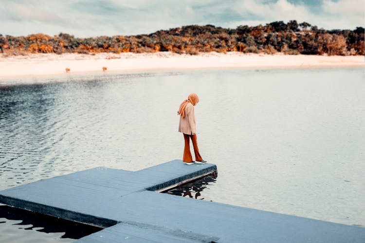 A Woman Standing On A Dock