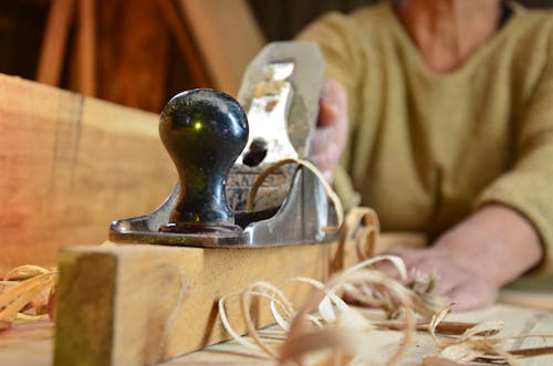 Person Using a Hand Plane on a Wood