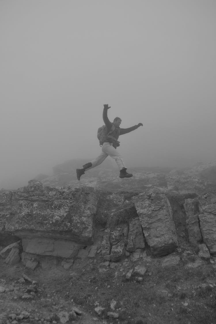 Person Jumping On Rocks