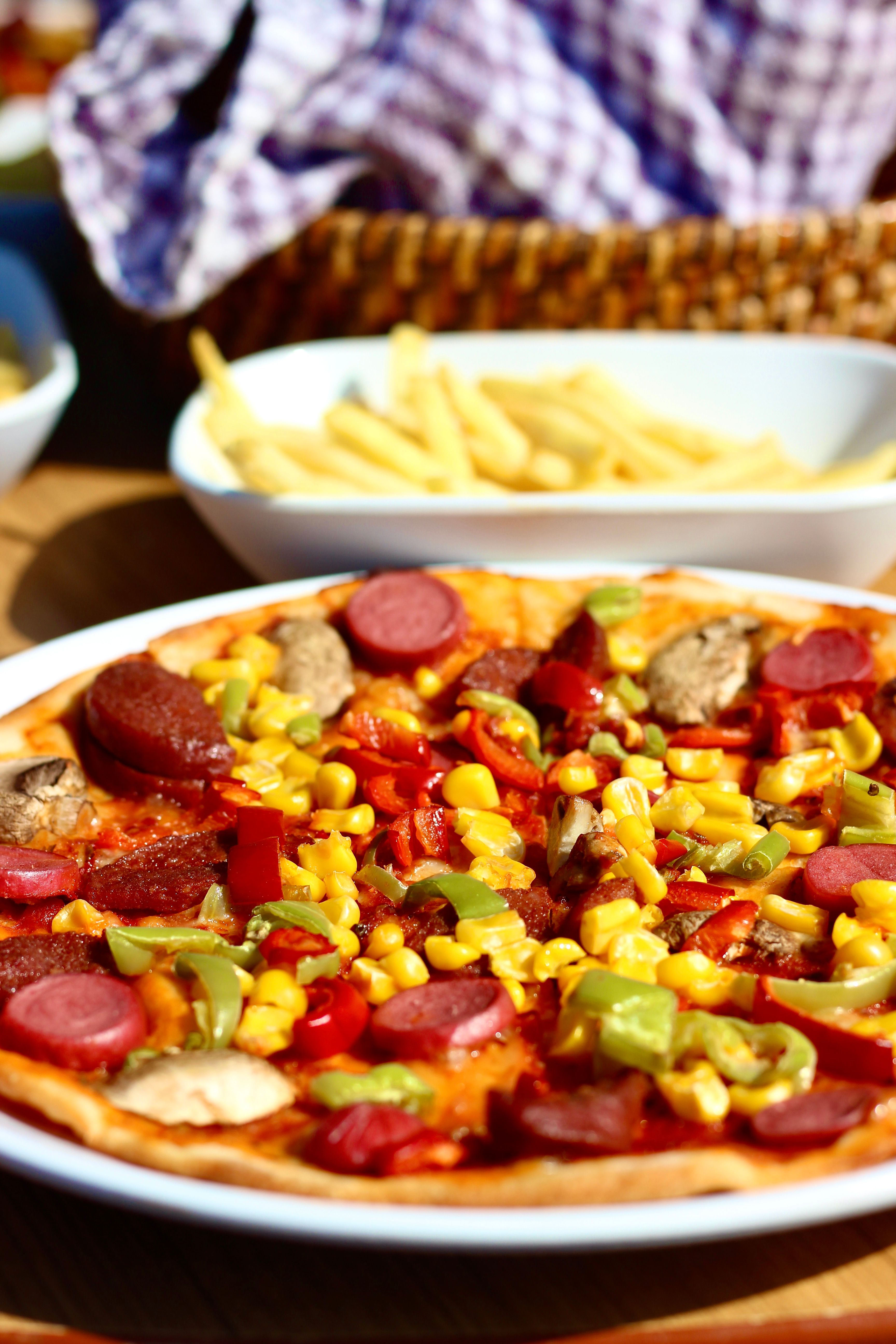 A vibrant close-up of a pizza loaded with vegetables and sausage, perfect for food lovers.