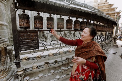 Nepali Woman Touching a Prayer Wheel