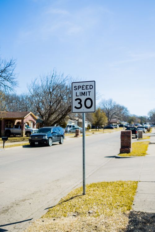 Free Speed limit 30 sign on a suburban street with cars and houses. Stock Photo