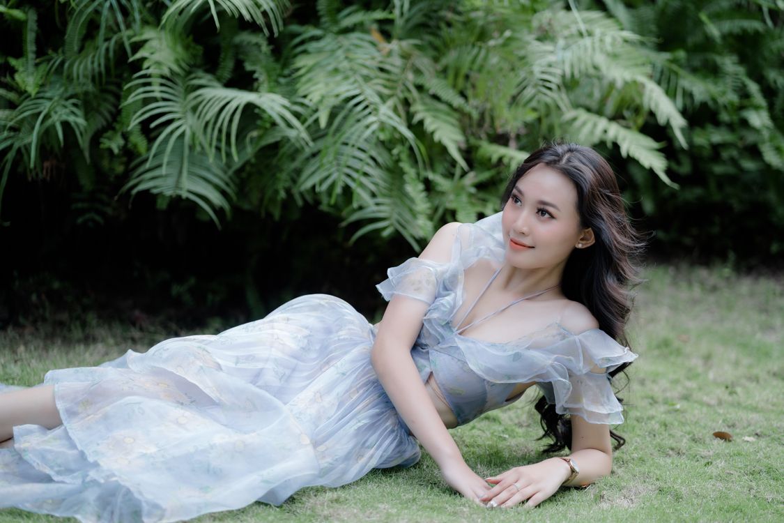 Beautiful Woman in a Dress Lying Down on Grass  Free Stock Photo