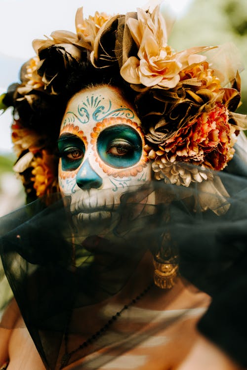 Woman in a Traditional Mexican Face Paint and a Floral Headpiece
