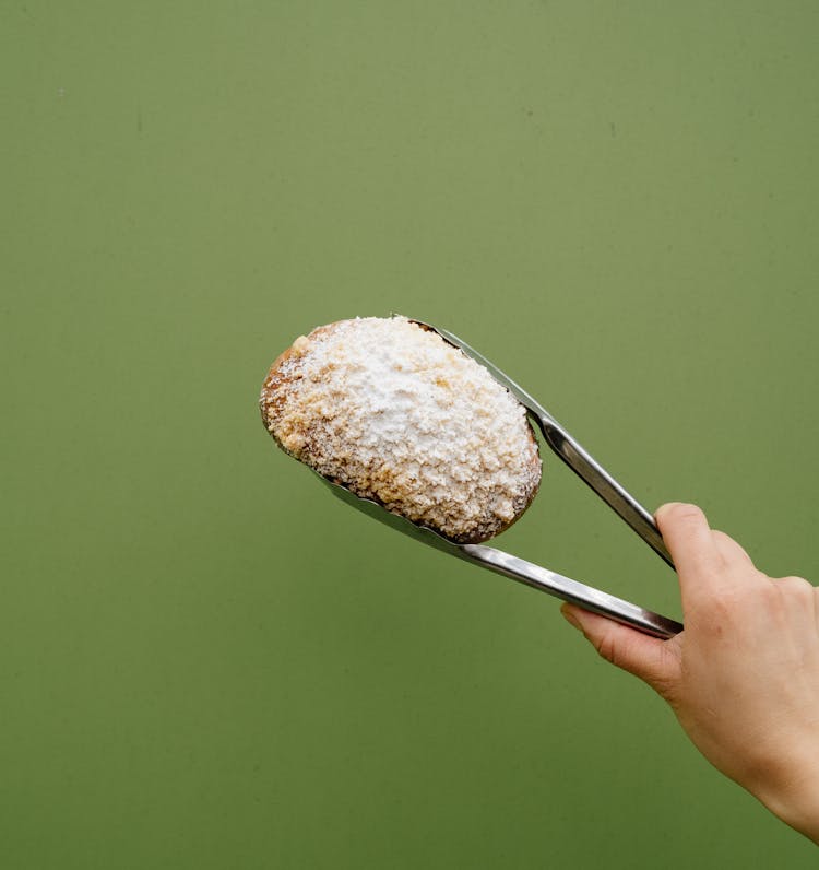 Metal Tongs Holding A Bread