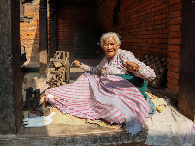 Elderly Woman Sewing Blanket