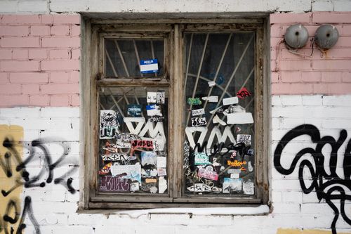 Free Close-up of a window covered with stickers and graffiti on an urban brick wall in Arkhangelsk, Russia. Stock Photo