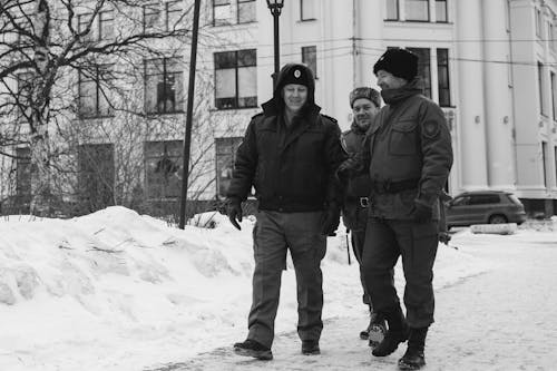 Black and White Photo of Men Walking on the Street During Winter