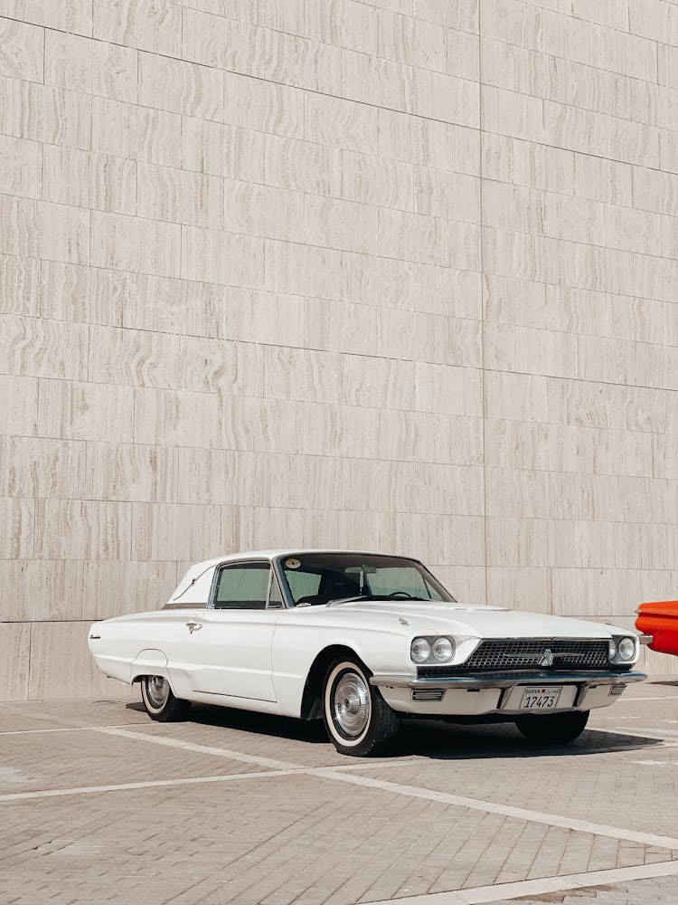 White Ford Thunderbird Parked Outside A Building