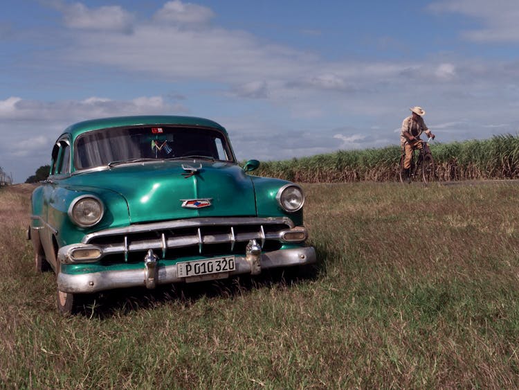 A Parked Vintage Car On A Grass Field