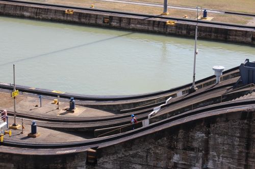 Free A worker wearing a blue hard hat descends a staircase at a canal lock during the day. Stock Photo
