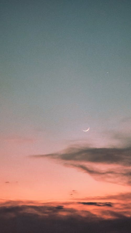 Crescent Moon on a Blue and Orange Sky White Gray Clouds