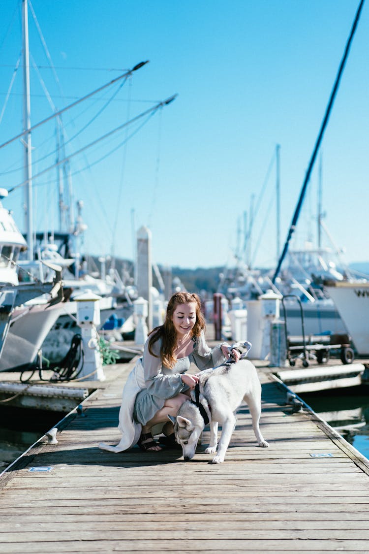 Woman Patting Dog On Pier