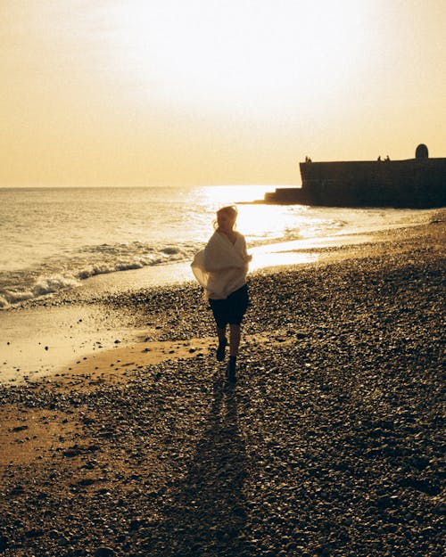 Woman Running on a Rocky Beach