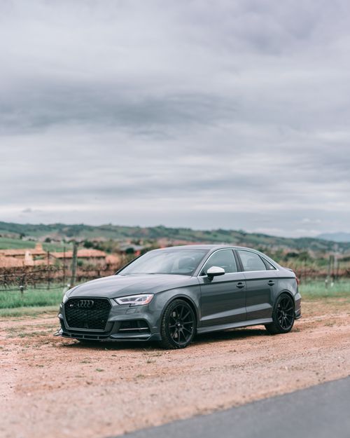 Free Black car parked on a quiet rural roadside, showcasing modern design and tranquil surroundings. Stock Photo