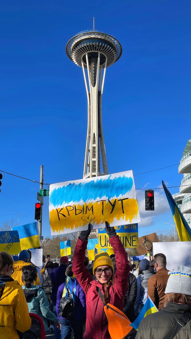 A Woman Holding A Placard While Protesting Near The Seattle Space Needle