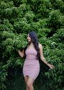 Woman in White Spaghetti Strap Dress Standing Near Green Plants