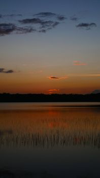Tranquil twilight scene over a reflective lake in Coba, Quintana Roo, Mexico.