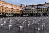 Rows of white plastic chairs in a symmetrical outdoor setting in A Coruña, Spain.
