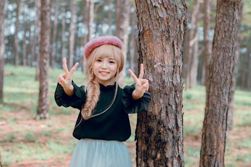 免费 穿黑衬衫的女孩站在树附近 素材图片