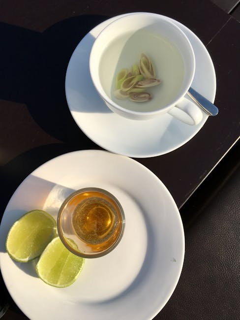 A steaming cup of Kenyan lemongrass tea with fresh lemongrass stalks in the background, bathed in soft, natural light.