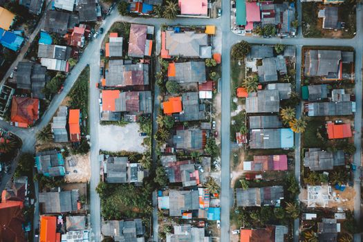 Drone shot of a vibrant residential area showcasing colorful roofs and organized streets from above.