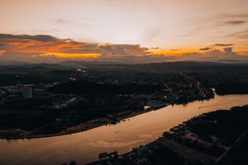 Free Stunning aerial view of a city by the river during sunset, capturing a scenic and vibrant skyline. Stock Photo