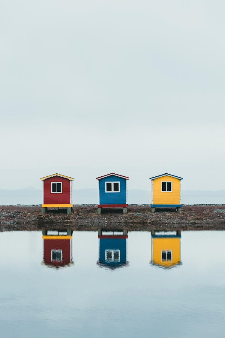 Identical Fishing Houses On Shore Painted In Cheerful Colours