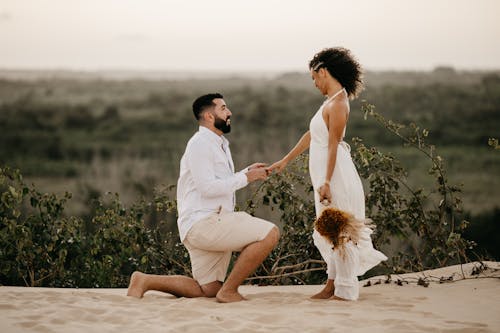 Hombre pidiendo matrimonio en la playa al atardecer