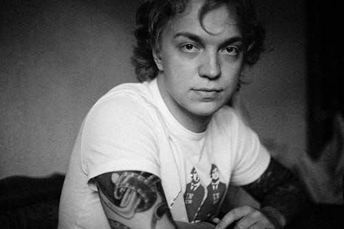 Grayscale Photo of a Tattooed Man Wearing a Shirt