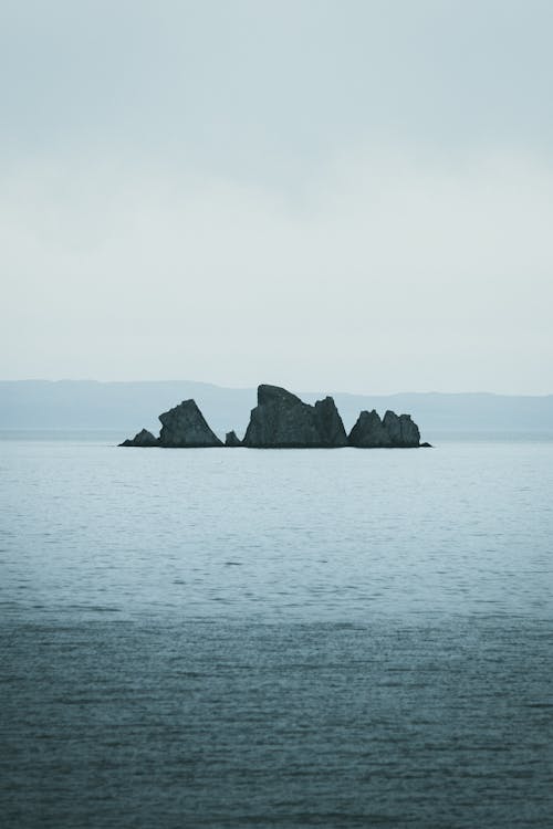 Free Lone Rock Formation on Sea Stock Photo