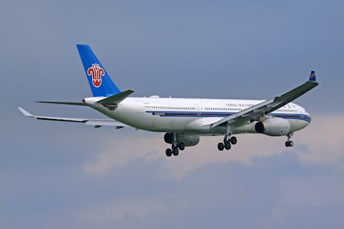 White and Blue Airplane Flying