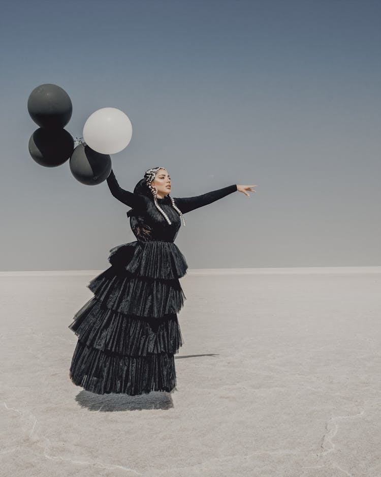 A Woman In Black Dress Floating In The Air