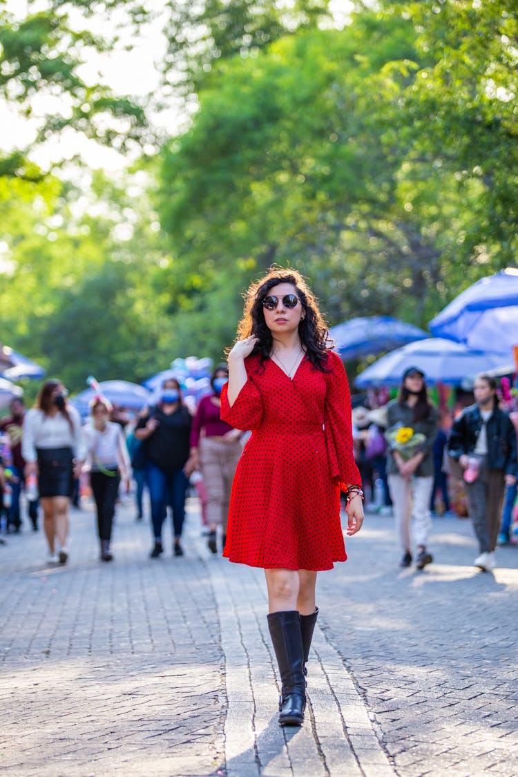 Woman In Red Dress And Boots Walking In The Street