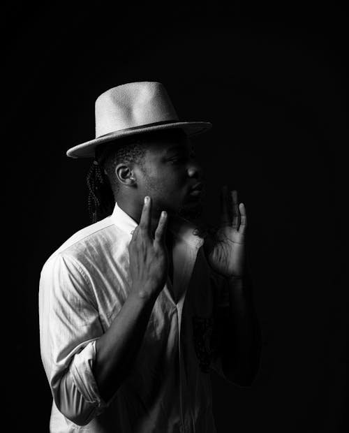 Grayscale Photo of a Man Wearing a Hat