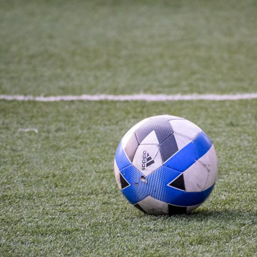 Free Close-up of a black and blue soccer ball resting on a green field, perfect for sports themes. Stock Photo