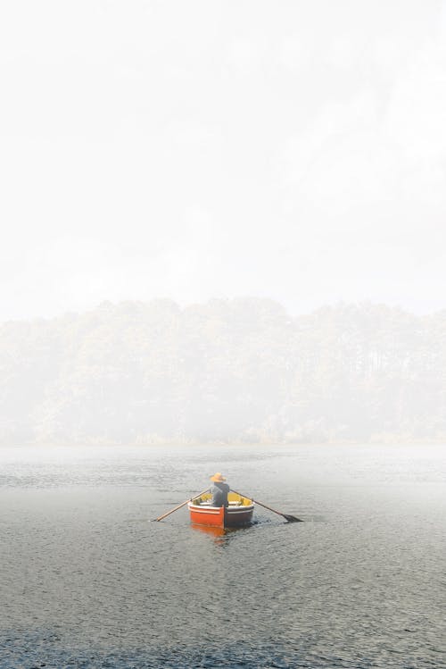 Back View Shot of a Person Riding on a Boat while Paddling