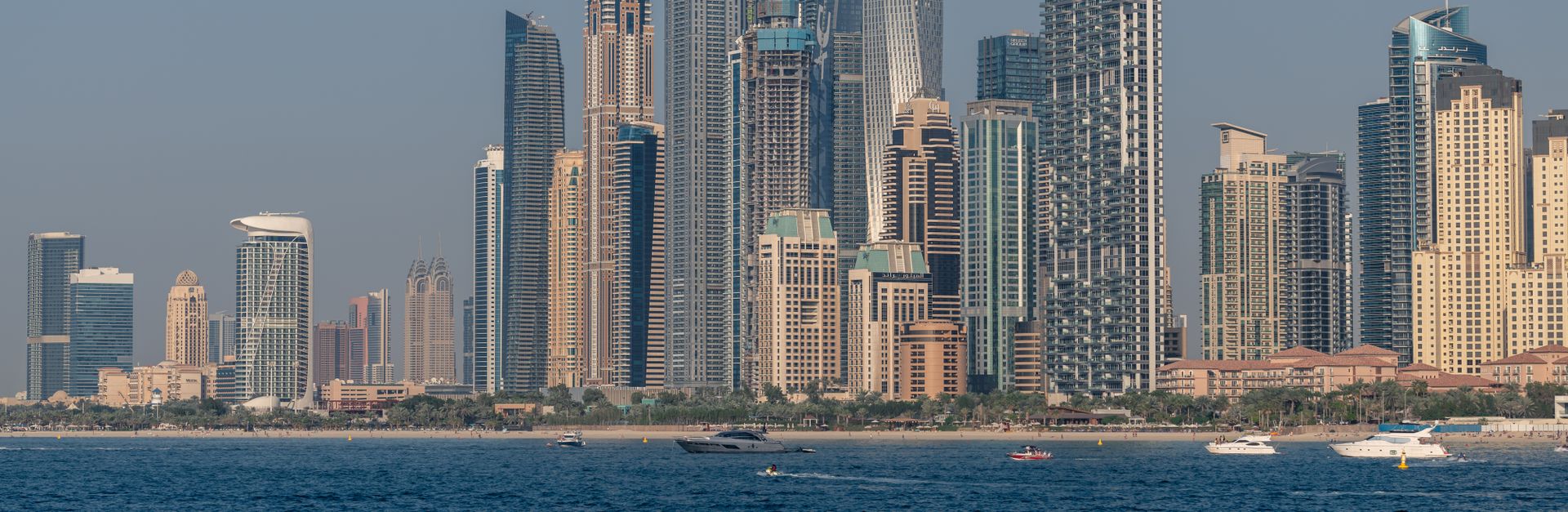 Breathtaking view of Dubai Marina's skyscrapers from the ocean during the day.