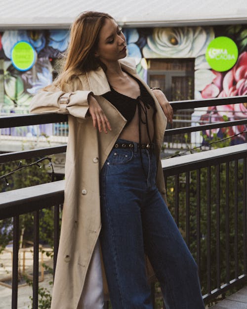 Woman in Black Top, Denim Jeans and Brown Trench Coat